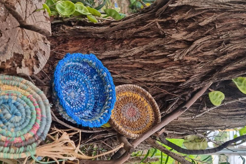 Baskets lying against a log.