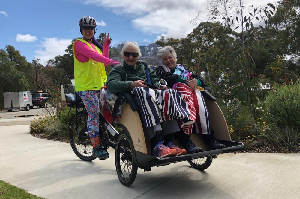 Two women riding in a trishaw bike
