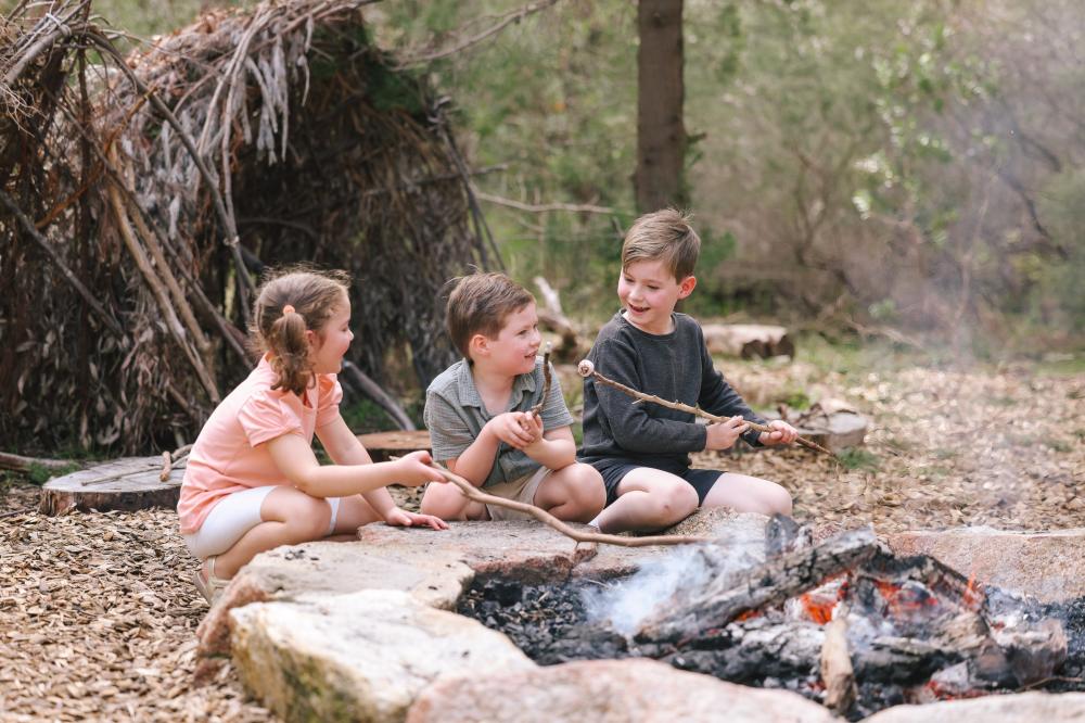 Children by a fire outdoors.