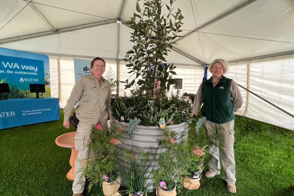 Two horticulturists beside a plant display.