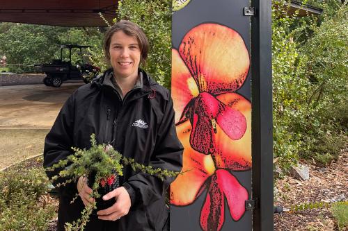Jo Blackburn standing by the Conservation Garden sign.
