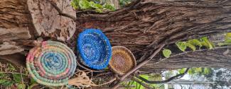 Baskets lying against a log.