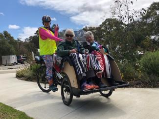 Two women riding in a trishaw bike