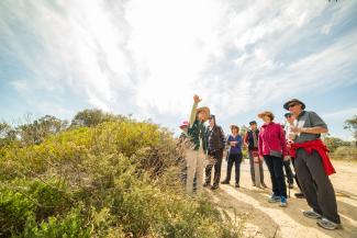 A volunteer guide speaking to a group of Bold Park visitors.