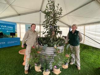 Two horticulturists beside a plant display.