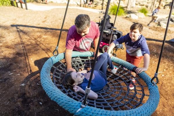 Children playing on accessible play equipment.